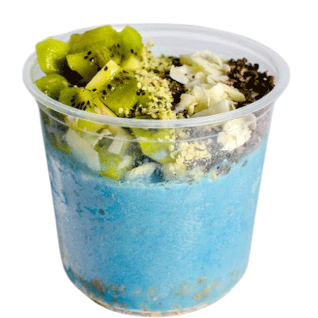 Blue spirulina smoothie bowl topped with kiwi, coconut flakes, cacao nibs, and superfood seeds